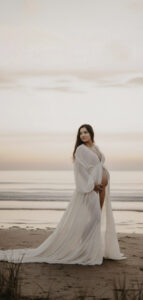 Robe de grossesse blanche vaporeuse à manches bouffantes, fluide et légère, parfaite pour une séance photo maternité en bord de mer à Hyères.