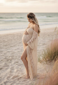 Robe de grossesse en dentelle beige, fluide et légèrement fendue, parfaite pour une séance photo maternité naturelle sur la plage ou dans la nature.