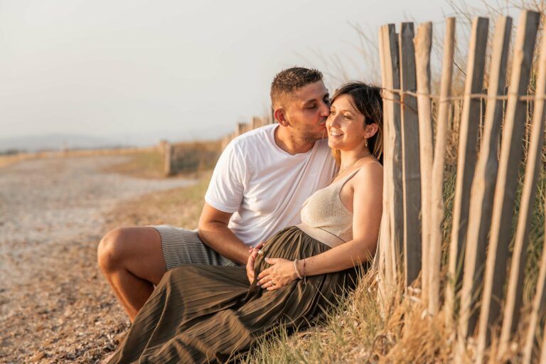 Photo grossesse en couple à Hyères, moment de tendresse près de la plage