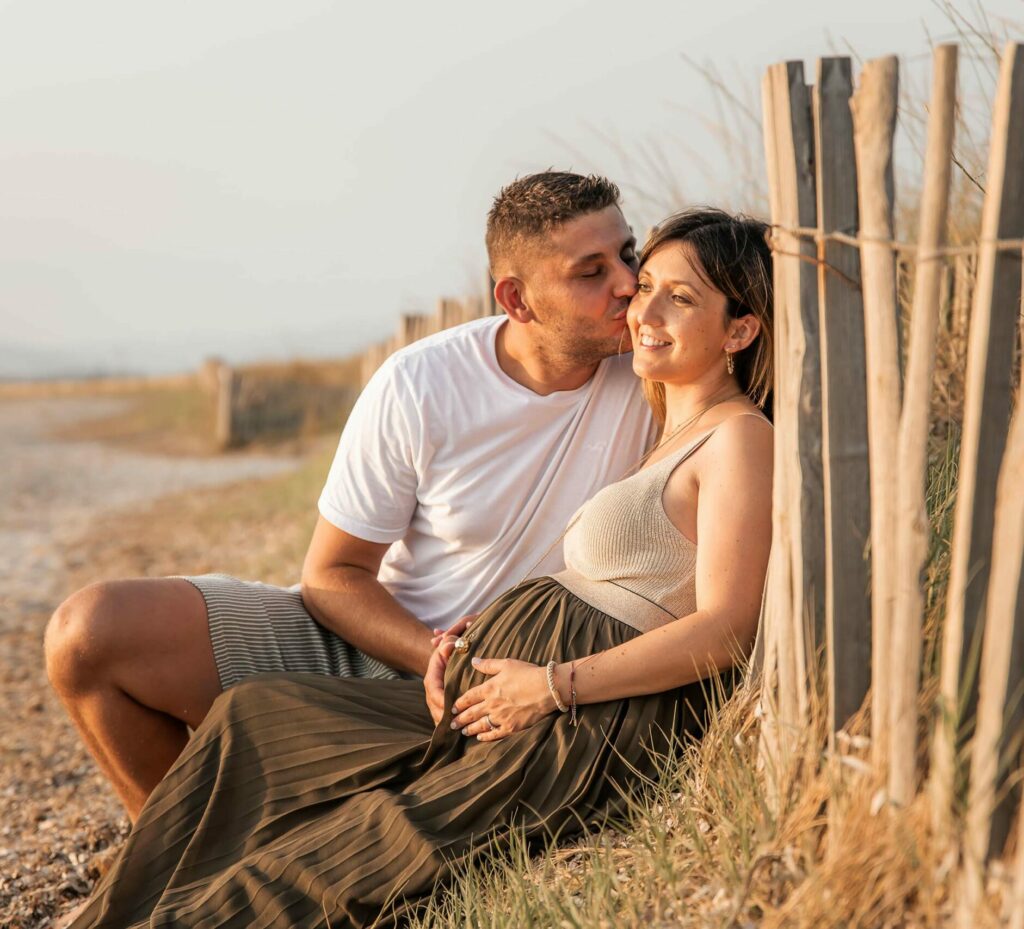 Photo grossesse en couple à Hyères, moment de tendresse près de la plage