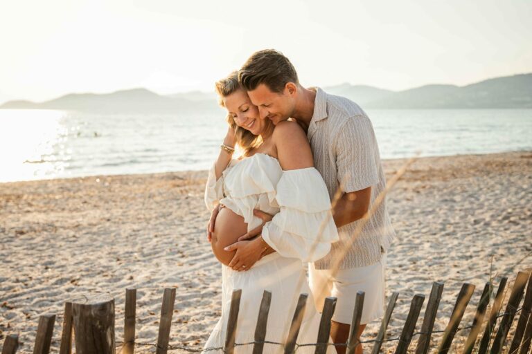 Photographe grossesse à Hyères, couple tendre sur la plage en robe blanche