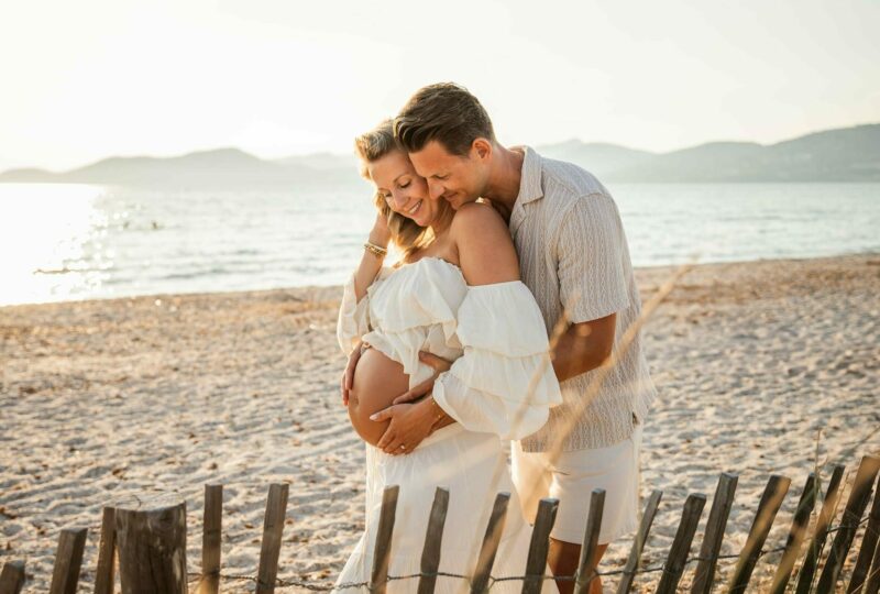 Photographe grossesse à Hyères, couple tendre sur la plage en robe blanche