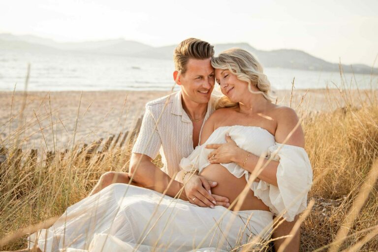 Séance photo grossesse en couple dans les herbes dorées à Hyères, lumière naturelle