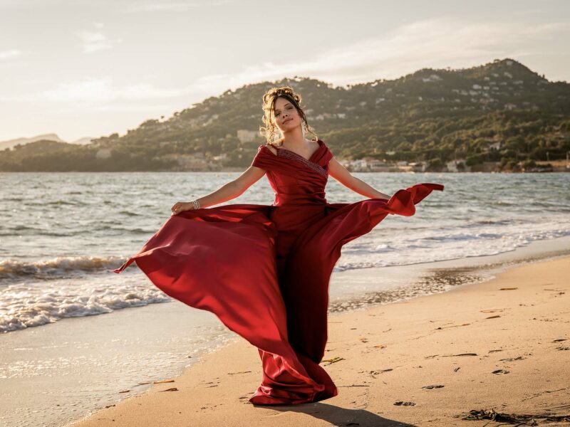 Portrait lifestyle féminin en robe fluide, ambiance bord de mer au coucher du soleil
