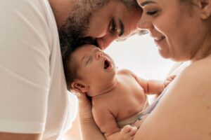 Séance photo naissance lifestyle à domicile à Hyères, bébé entouré de ses parents dans un moment de tendresse