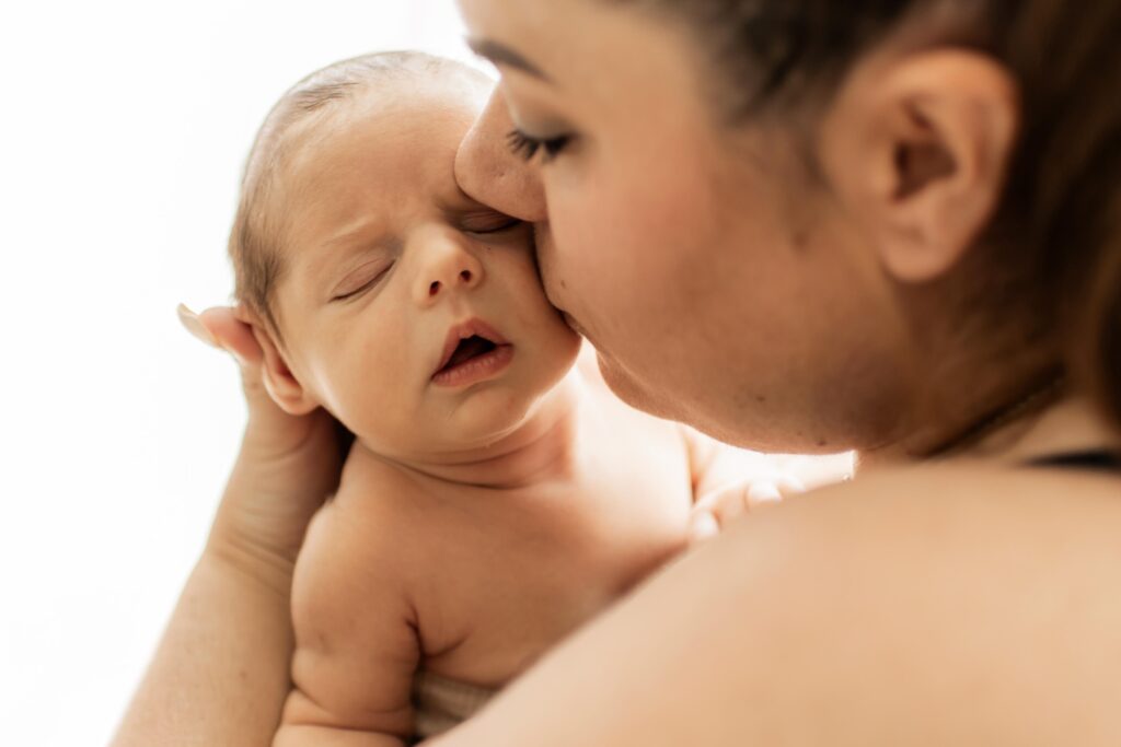 Photo naissance lifestyle à Hyères – nouveau-né dans les bras de sa maman, moment de tendresse à domicile