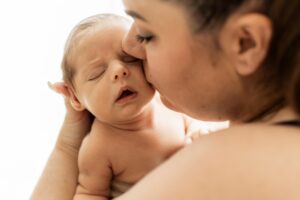 Photo naissance lifestyle à Hyères – nouveau-né dans les bras de sa maman, moment de tendresse à domicile